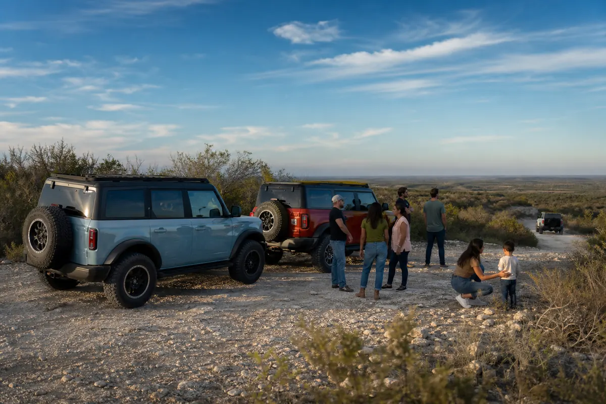AI-generated concept scene, three off-road vehicles and fictional families at a South Texas trail overlook.